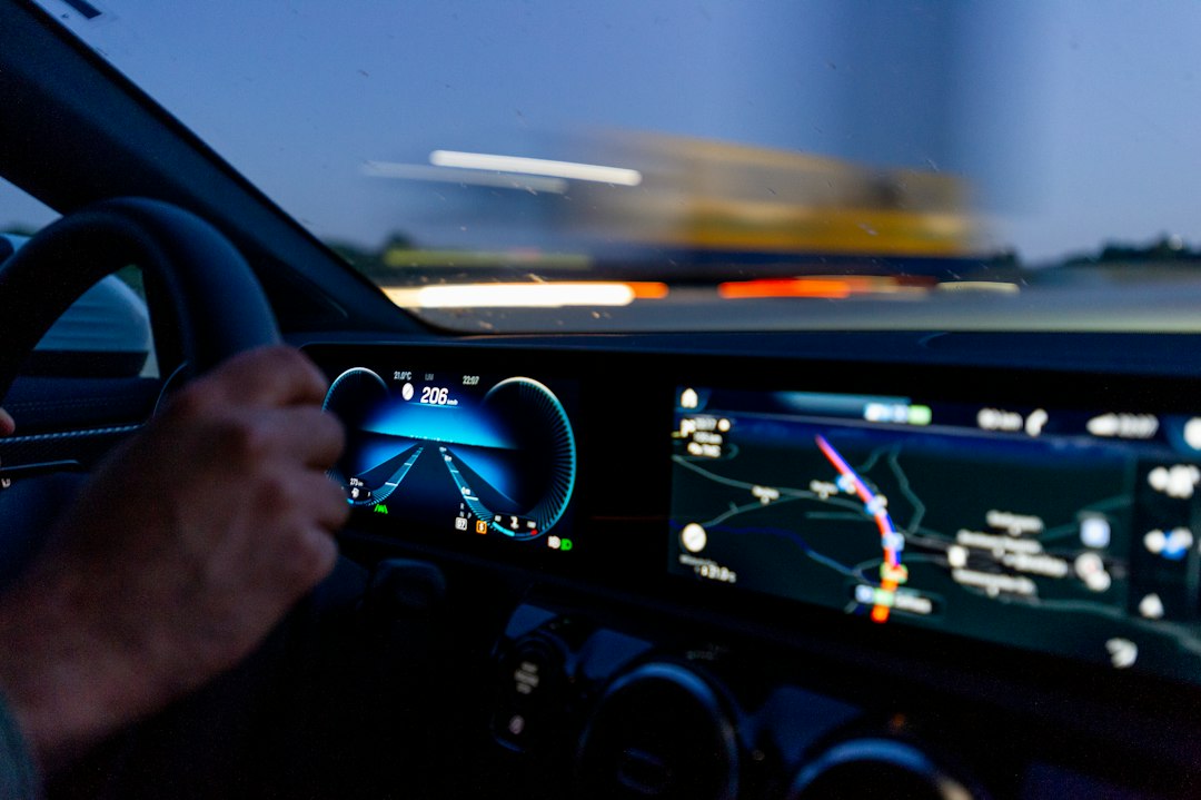 Pengemudi memegang setir mobil dengan panel instrumen modern